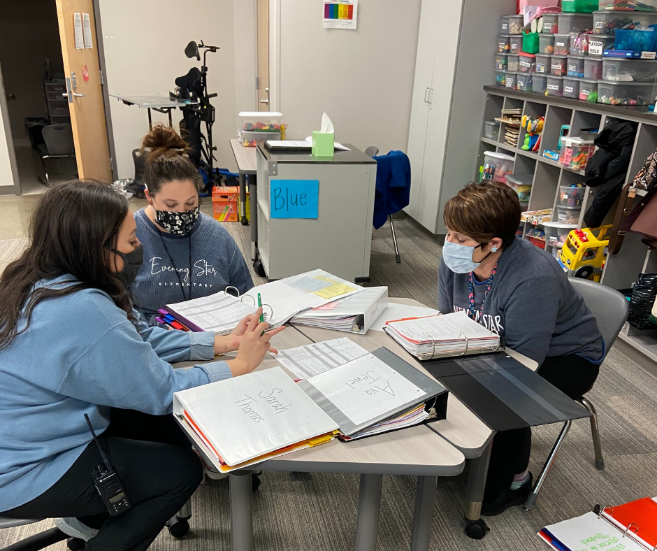 This image shows a team reviewing student data in student data binders.